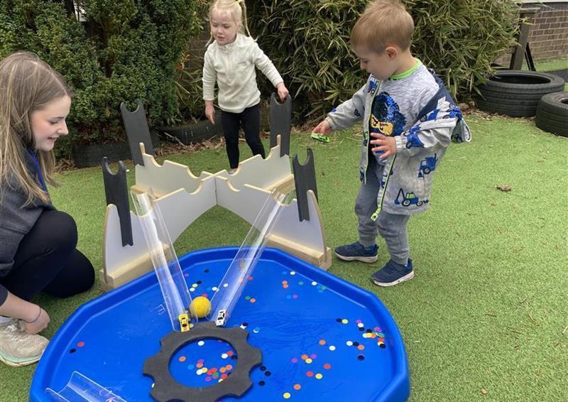 2 children playing on the tuff spot tray in their playground setting